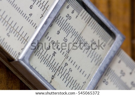 high-precision hand-held calculating tools - logarithmic ruler  brown wooden background