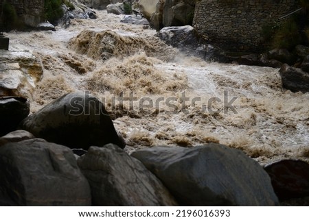 High-pressure flood water in mountain river tributary, caused by global warming, melting glaciers, and torrential rains. This has caused devastation in Pakistan

With selective focus  depth of field.
