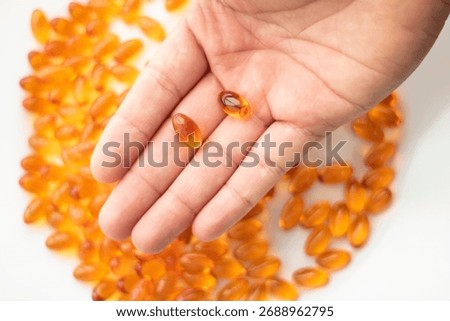High-quality close-up of vitamin E and omega-3 capsules on a clean, neutral background. These softgel supplements represent essential nutrients for heart health, immune support, and overall wellness. 