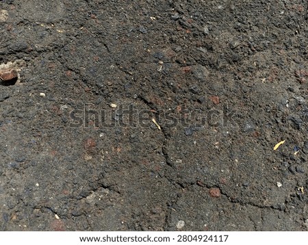 High-quality dark asphalt texture background with rough stones and realistic ground cracks, perfect for 3D overlay, design backdrop, or urban gritty texture.