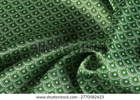 High-quality green and white patterned textile fabric with a repetitive geometric fan design and elegant drapes.