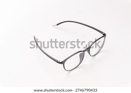 ​This high-quality studio shot features a pair of modern round eyeglasses with a sleek matte black frame, perfectly positioned against a clean, neutral white background. The eyewear showcases a timeless Panto-style silhouette, blending vintage inspiration with contemporary minimalism. Designed with slim, lightweight temples and a subtle blue-light reflective coating on the lenses, these glasses represent the ideal fusion of style and functional eye protection for the digital age. The high-angle perspective emphasizes the elegant curves of the frames and the durable construction of the hinges, making it a versatile accessory for both professional business attire and casual everyday wear. This crisp, minimalist composition is perfect for optical retail catalogs, fashion editorials, and healthcare-related marketing materials.