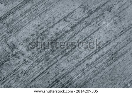 High-resolution background texture of a dark grey concrete surface featuring prominent brushed lines, rough combed cement patterns, and a gritty distressed industrial grunge aesthetic