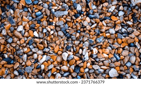 A high-resolution close-up of a gritty texture formed by a mixture of gravel and various stones. This rough and grunge texture can add depth and character to your design projects.