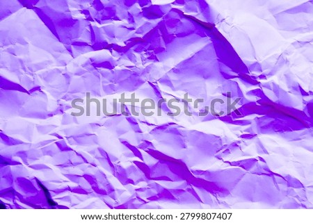 A high-resolution, full-frame background texture of crumpled purple paper, with complex network of sharp creases, deep folds, and dramatic shadows that create an intense three-dimension.
