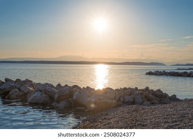 High-resolution image capturing a breathtaking sunset over the Croatian Adriatic coast on June 20, 2024. The photograph showcases the vibrant hues of the setting sun reflecting off the calm sea.