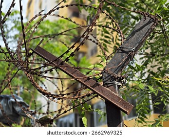 A high-resolution image showcasing a security razor wire fence installed along the top of a boundary wall. The sharp, coiled razor wire is mounted on metal brackets for enhanced perimeter protection. 