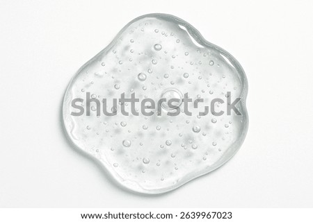 High-resolution macro image of a transparent, thick gel droplet with air bubbles, irregular shape and glossy texture on a clean white background. Skincare, cosmetics, or medical-themed visuals