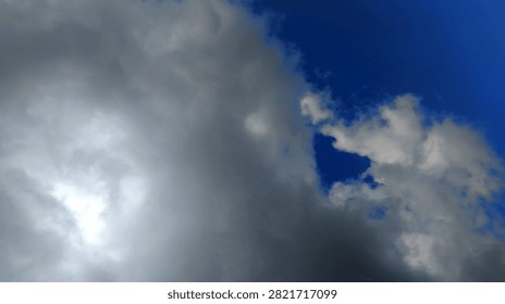 High-resolution photograph of dramatic storm clouds partially covering the sun against a deep blue sky. Ideal for weather, climate, nature, environmental concepts, and creative background designs.
