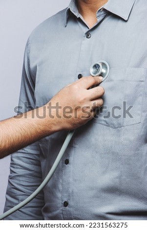 High-Resolution stock photo of doctor's routine check-up. Close-up of a doctor examining the patient's vital chest with the stethoscope. The doctor checks the patient's heartbeat with a stethoscope.