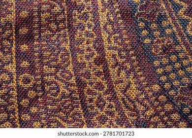 High-resolution textile texture background with elaborate gold, red, and black woven pattern, intricate fabric design for interior and fashion backdrop.