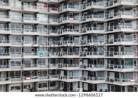 high-rise building with balkonies with blue balustrades shows living in a completely uniform way