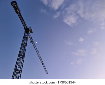 High-rise Crane For Construction On Sky Background. Tower Cranes For Rent With Installation At Construction Site. Sale Tower Crane During Economic Crisis. Crane Job Loss During Pandemic