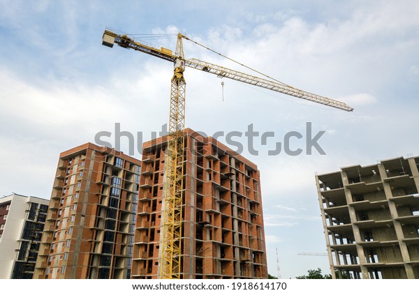 High-rise\
residential apartment buildings and tower crane under development\
on construction site. Real estate\
development.