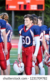 Highschool American Football Player Getting Ready For His Game On The Sideline.