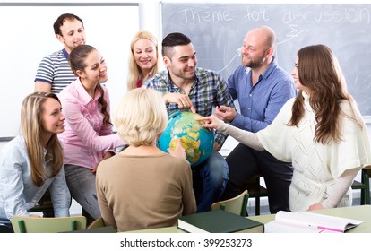 Highschool Students Having Fun With A Globe At Geography Class During A Break In A Classroom