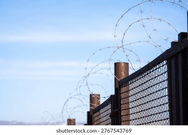 High-security prison area with barbed wire fencing and restricted access, symbolizing confinement, law enforcement, controlled environment, and strict protection of a secure facility.