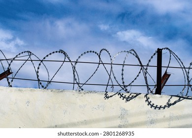 High-security wall topped with razor wire. 