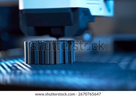 A high-tech 3D printer works efficiently in a workshop, layering materials to form an intricate object while ambient blue lighting highlights the creative atmosphere.