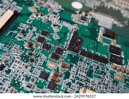 High-tech background with circuit board texture. Semiconductor surface mount components and connection lines on the electronic circuit. Selected focus.