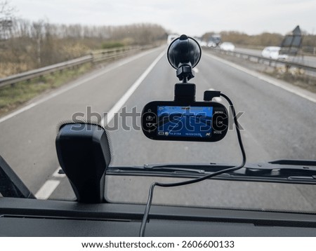 A high-tech dashboard camera mounted in an HGV (lorry truck), recording a clear view of the road during driving. Dashcam are essential for fleet safety, accident documentation, and driver monitoring