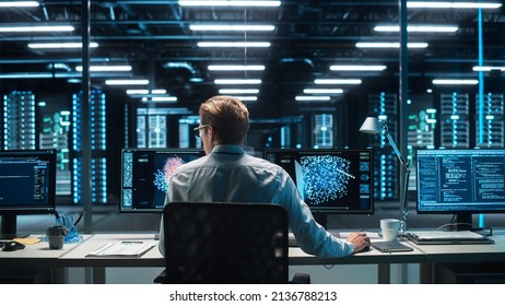 High-Tech Data Center Server Control: IT Specialist Administrator Working On Computer, Screen Advanced Showing Big Data AI Analysis. Web Services, Cloud Computing, Analytics Facility, Cyber Security