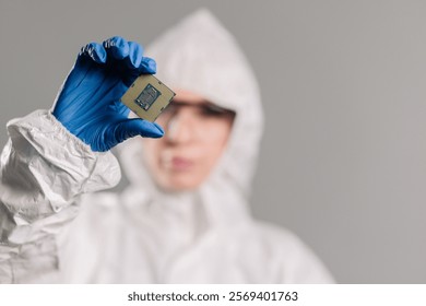 In a high-tech electronics factory, a design engineer in a sterile coverall examines a microchip with gloves, perfect for showcasing innovation, precision engineering, and advanced manufacturing.