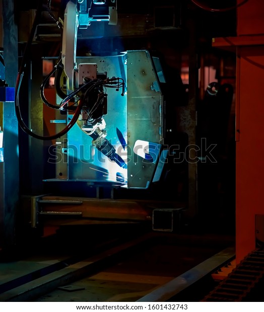 High-tech industry\'s heavy robotic arm is welding\
the iron frame