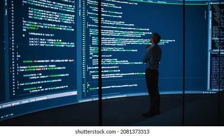 High-Tech Startup Concept: Innovative Male Software Engineer Standing, Doing Big Data Analysis on Wall Screen Showing Porgramming Code. Developing Futuristic e-Commerce App with Machine Learning. - Powered by Shutterstock