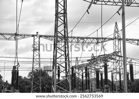High-voltage electrical substation featuring interconnected power lines, large insulators, transformers, and structural elements. Representing industrial infrastructure and energy distribution