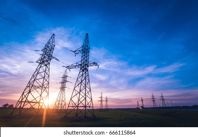 High-voltage power lines at sunset. Electricity distribution station. Background