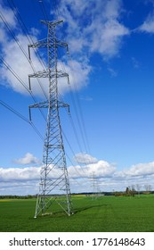 High-voltage Power Transmission Line In A Cereal Field On A Background Of Blue Sky