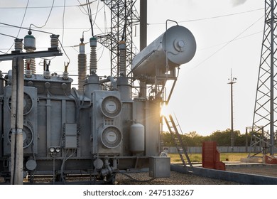 High-voltage transformer at a substation with an expander and insulators.