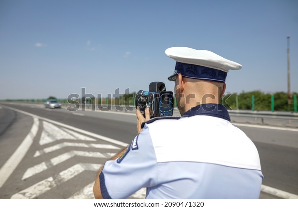 Highway 2\
Bucharest - Constanta, Romania - 10 August, 2021: Romanian Road\
Police officer uses a radar speed\
gun.