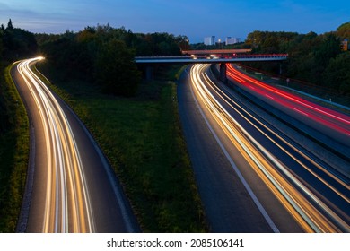 Highway B236 Crossing B1 In Dortmund Ruhr Basin Germany. Junction At Dusk With Light Traces Of Passing Fast Cars And Blue Evening Sky. Long Time Exposure From A Bridge With White And Red Lights.