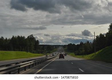 Highway with dark clouds and clear sky in the distance