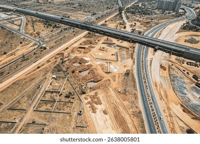 Highway interchange construction in India with elevated roads and earthmoving machinery shows urban infrastructure growth and modern transportation development.