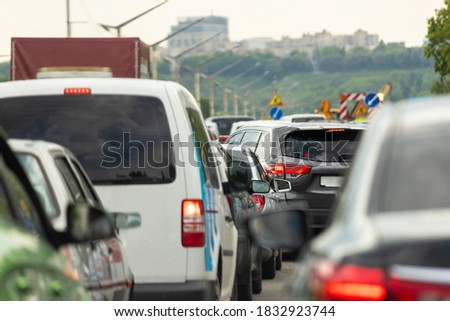 Highway interstate road with car traffic jam and Kiev on background. Motorway bumber barrier gridlock due country border control point. Vehicle crash accident and queue bottleneck on freeway
