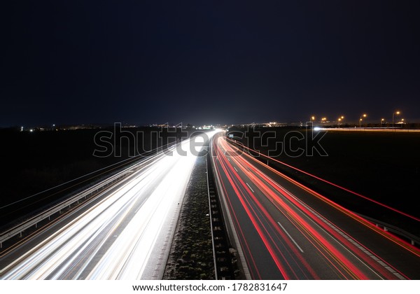 Highway light car trails leading from passing cars\
during night.