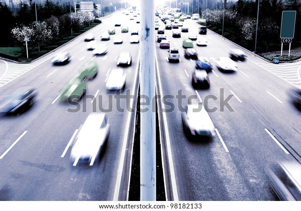 Highway with lots of cars. Blue tint, high\
contrast and motion blur to rise\
speed.