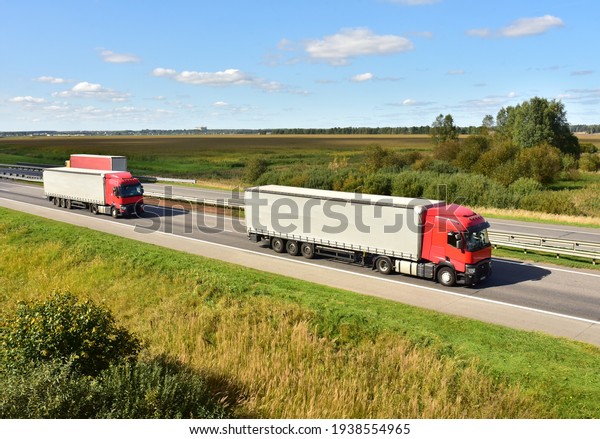 Highway with Lots of semi-trailer trucks . Big lorry
traffic on the road. Truck driving along on roadway overtakes
another truck. Services and Transport logistics. Russia, Moscow,
JUN 07, 2020