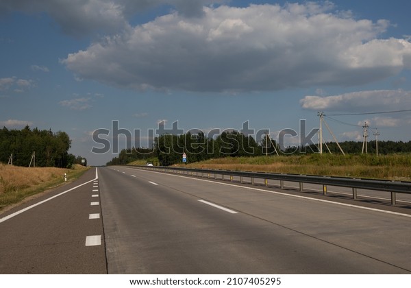 highway road in the\
countryside, roadside and asphalt, green forest and blue sky on a\
sunny day	