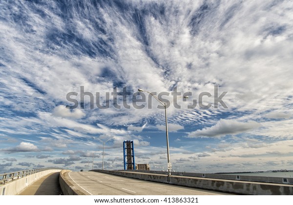Highway road with street lamps outdoor sunny\
weather on cloudy blue sky\
background