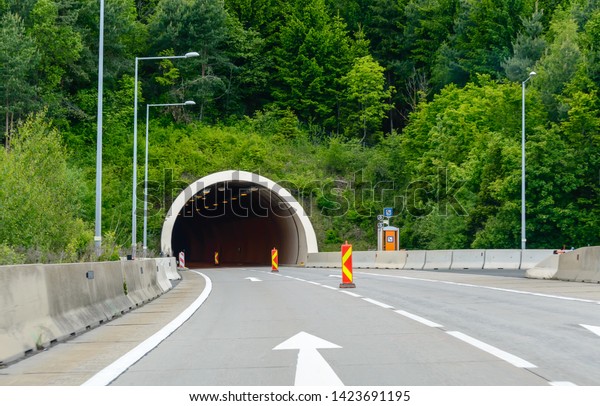 Highway\
road tunnel in the mountain with traffic dividers to mark a\
construction site. Motorway in Austrian\
Alps.