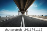 Highway road under the overpass with clear blue sky.