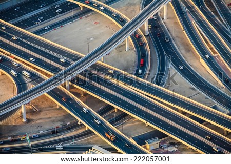 Highway roads with traffic in a big city (Dubai) at sunset. Transportation concept. 