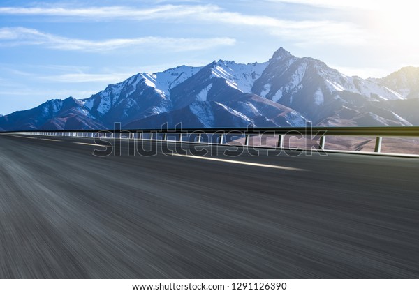 A highway with snow-capped mountains and
grasslands in the background