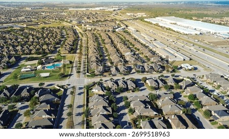 Highway stack interchange, pedestrian bridge, open plain from Castle Hills in Lewisville, TX with upscale two-story homes, median street, immature landscaping, HOA pool, tennis court, warehouse. USA