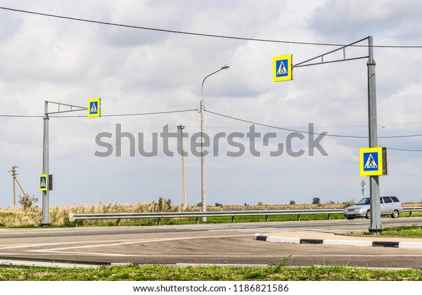 Highway in the steppe. Lamp posts, electrical wires.\
Sunny day. Road sign