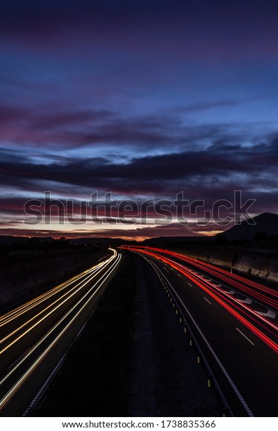 Highway at sunset with cars\
in motion